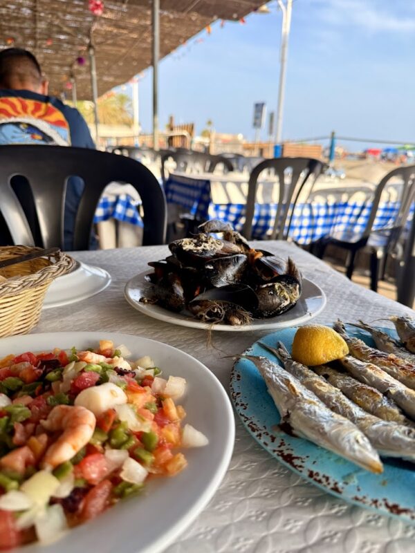 El Tintero restaurant on El Palo beach, Malaga - waiters walking with seafood plates to auction