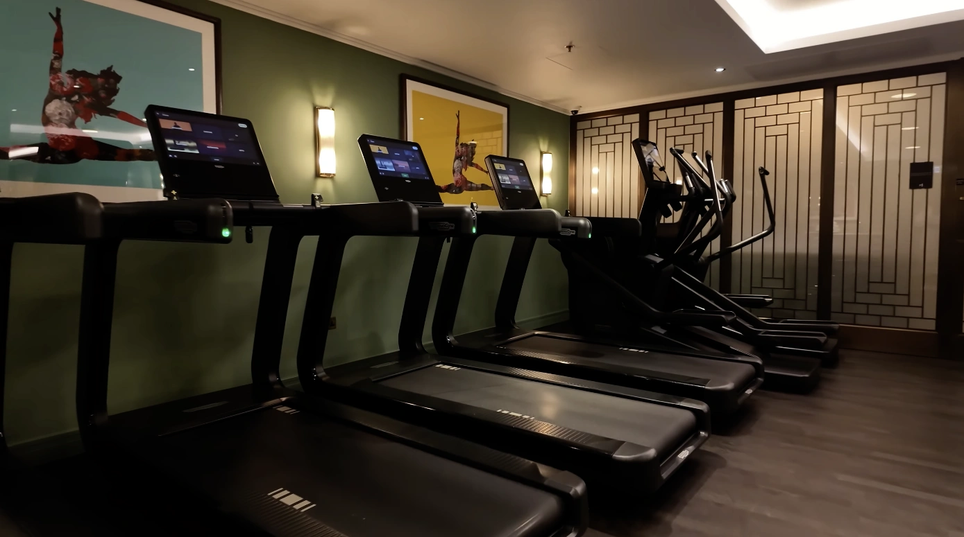 The Langham London gym — Technogym treadmills with green walls and artwork