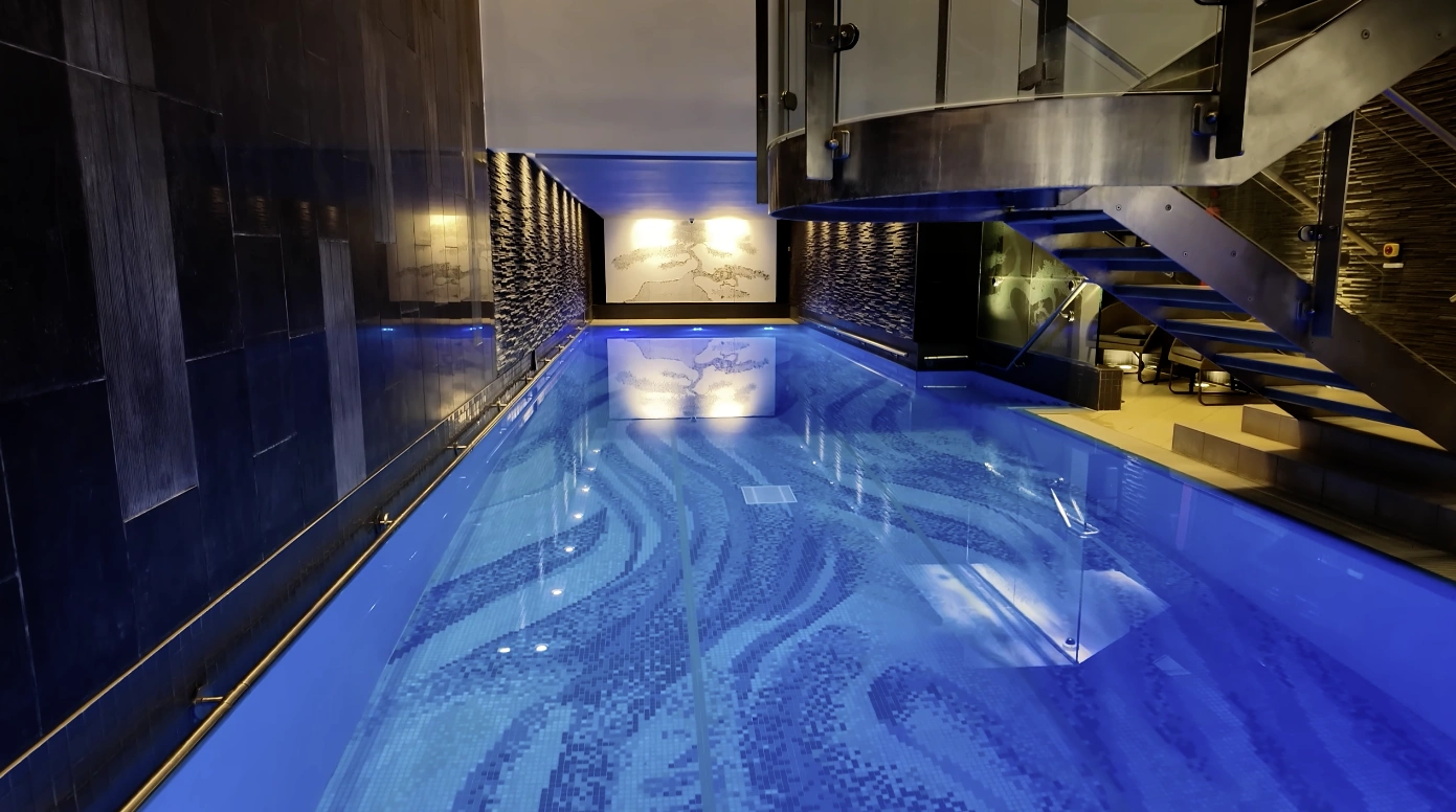 Chuan Body + Soul — 16m indoor pool with blue lighting and mosaic tiles at The Langham London