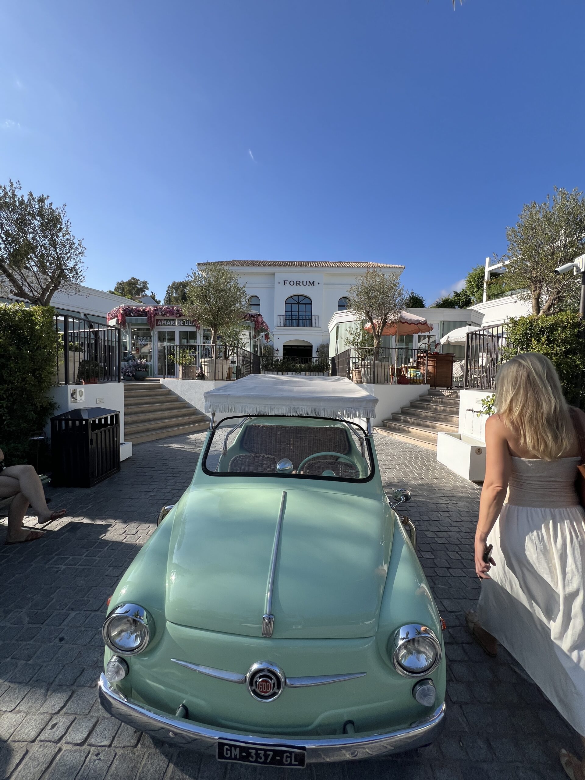 Vintage Fiat 600 parked at the entrance of Forum Marbella on the Golden Mile